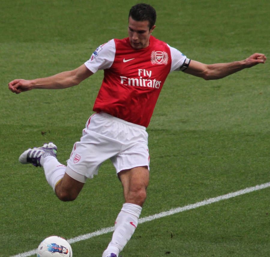 Robin van Persie mid-strike in Arsenal kit, captain's armband visible, 2011–12 season